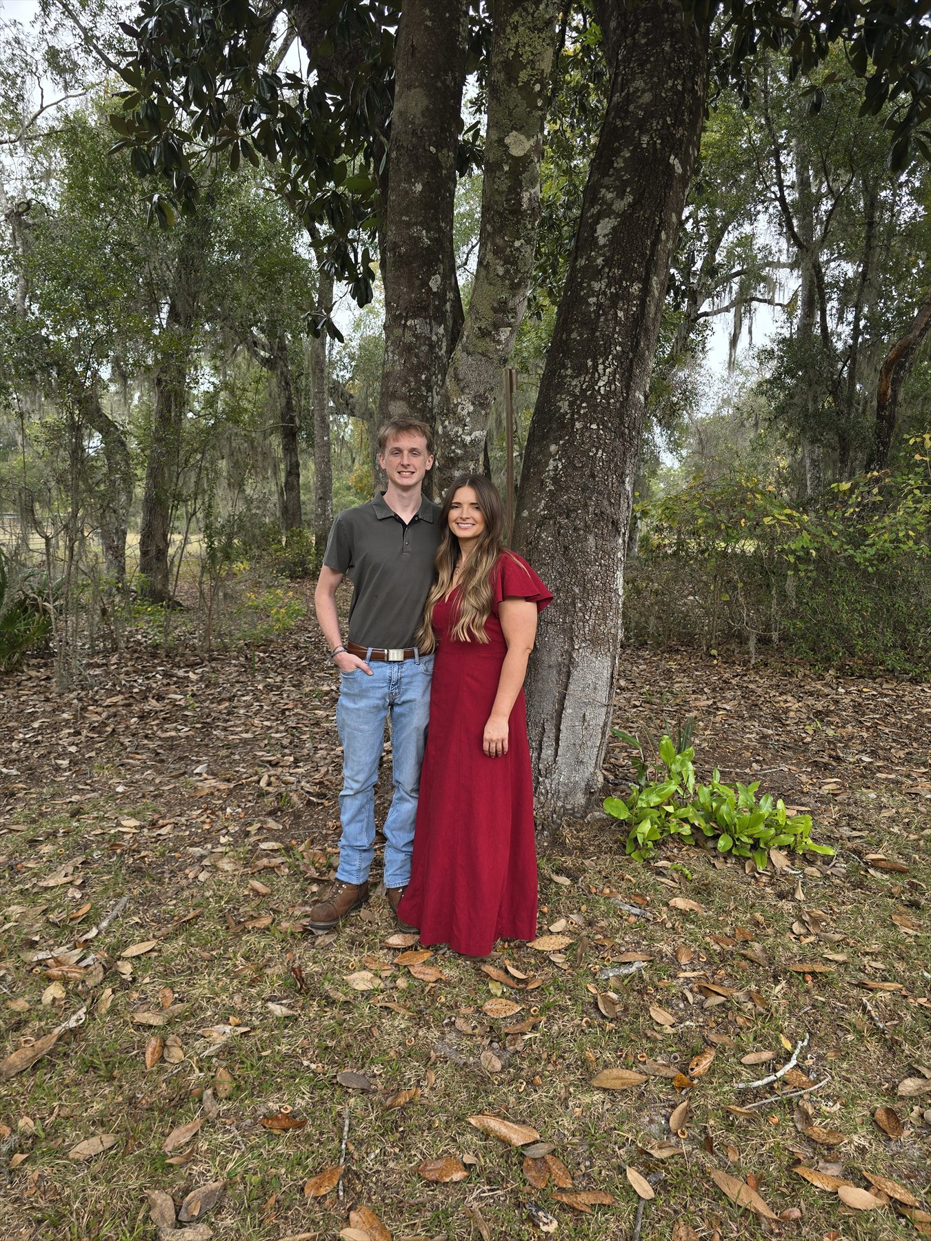 Hannah and Lucas dressed up together beneath the trees