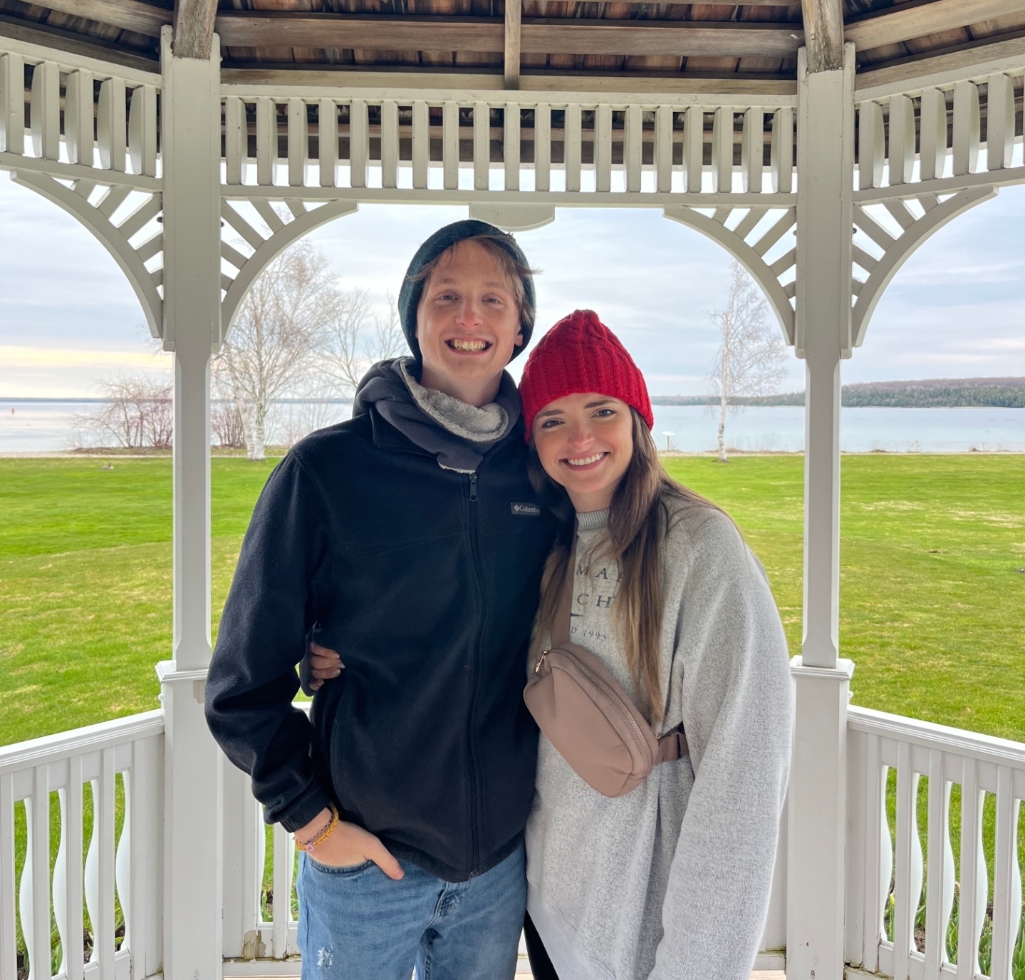 Hannah and Lucas smiling together beneath a lakeside gazebo